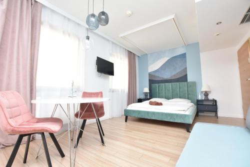 ヴロツワフにあるThe Goat Apartments Wrocław Rynekのベッドとテーブルと椅子のある寝室
