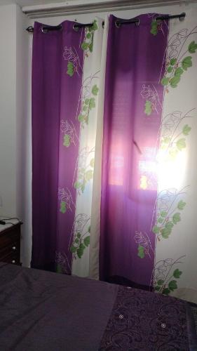 a bedroom with purple curtains with plants on the wall at Habitación con Vistas Preciosas en Piso Compartido in Estepona