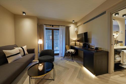 a living room with a couch and a desk in a room at Belle Marivent Mediterranean Petit Hotel in Palma de Mallorca