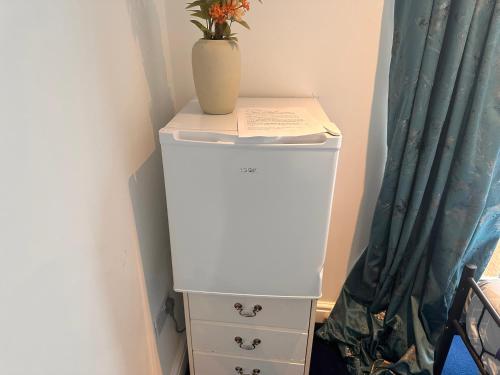 a white dresser with a vase on top of it at Quiet room in Hornchurch near Romford station on Elizabeth line to and from Heathrow airport in Romford