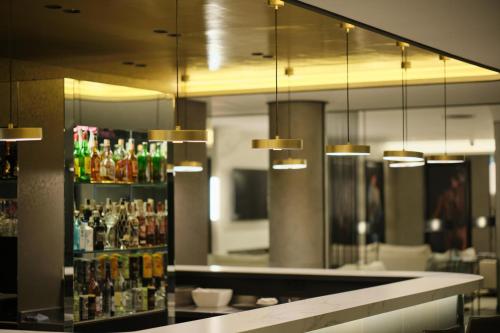 a bar with a counter with bottles of drinks at 1881 Madrid Ventas Hotel in Madrid