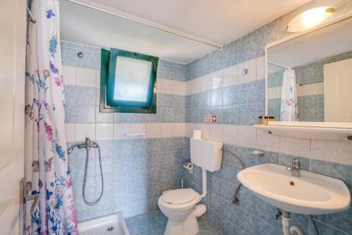 a bathroom with a toilet and a sink and a shower at Anna Studios in Arillas