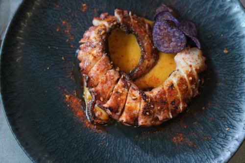a plate of food with a pretzel and onion rings at 1881 Madrid Ventas Hotel in Madrid