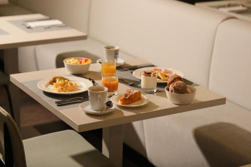 a table with plates of food and drinks on it at 1881 Madrid Ventas Hotel in Madrid