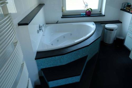 a bath tub in a bathroom with a window at Luxurious apartment including wellness in Poing