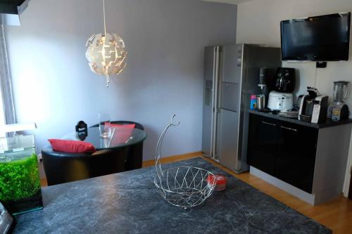 a kitchen with a counter with a refrigerator and a table at Luxurious apartment including wellness in Poing
