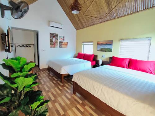two beds in a room with red pillows at Sky Bay Lodge in Ha Giang