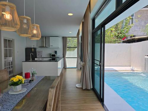 a kitchen and a living room with a swimming pool at Joy Homes Private Pool Villa in Chiang Mai
