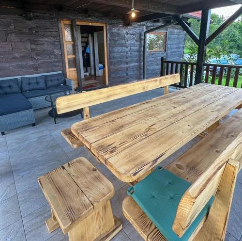 a wooden table and benches on a patio at Kuca Breg in Slapnica