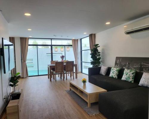 a living room with a couch and a table at Joy Homes Private Pool Villa in Chiang Mai