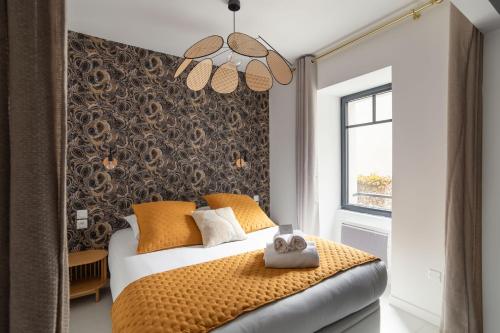 une chambre avec un lit avec des oreillers orange dans l'établissement Ty Peskaiden 1 - à Cancale vue mer, à Cancale