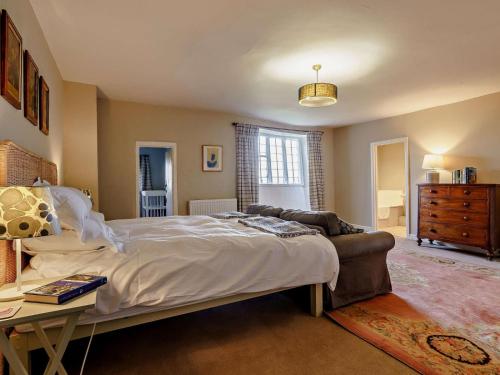a bedroom with a bed and a couch and a table at Elizabethan Manor at gateway to the Brecon Beacons in Abergavenny