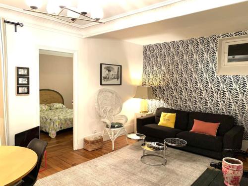 - un salon avec un canapé et une chambre dans l'établissement Beau 2P au pied de Montmartre, à Paris