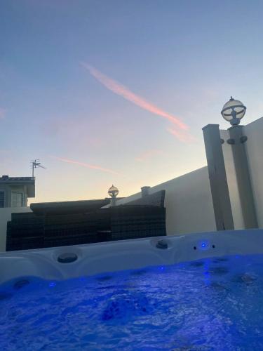 a hot tub with blue water in front of a building at Premium accommodation with luxury HOT-TUB and decking area, near Fantasy Island in Ingoldmells