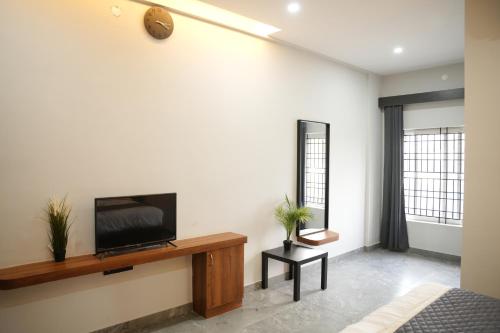 a living room with a flat screen tv on a wall at Sarvam Residency in Sāgar