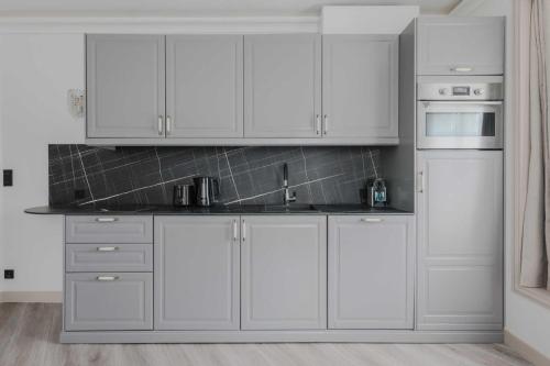 une cuisine avec des armoires blanches et un évier dans l'établissement Charming apartment - 1BR-4P - Arc de triomphe, à Paris