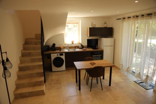 une cuisine avec une table et une cuisine avec un escalier dans l'établissement La Bastide au coeur de la Provence, à Pertuis