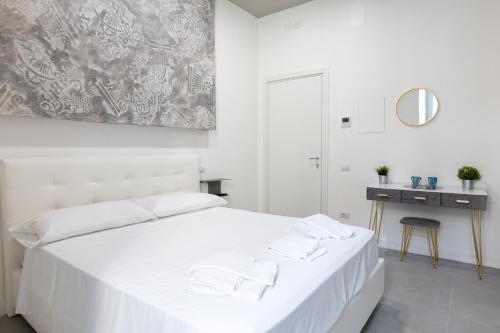 a white bedroom with a white bed and a mirror at Relais Palazzo Nizza - Luxotel & Apartotel in Salerno