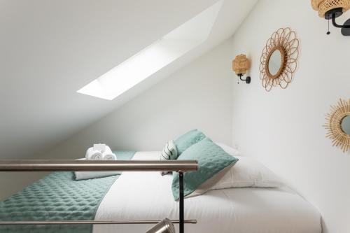 Ce lit se trouve dans un dortoir aux murs blancs. dans l'établissement Ty Peskaiden 3 - Appt proche de la plage, à Cancale