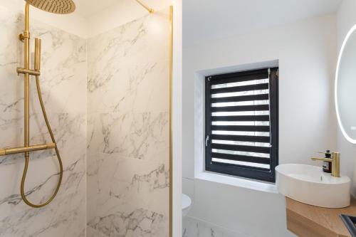 une salle de bain avec une douche, un lavabo et un miroir dans l'établissement Ty Peskaiden 3 - Appt proche de la plage, à Cancale