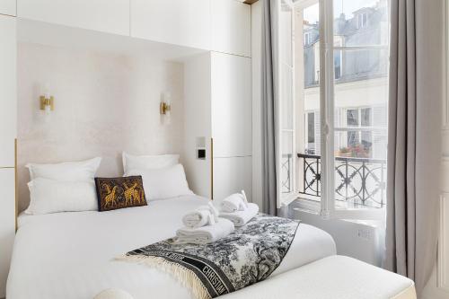 une chambre d'hôtel avec deux lits et une fenêtre dans l'établissement Pick A Flat's Apartment in Le Marais - Rue Filles du Calvaire, à Paris