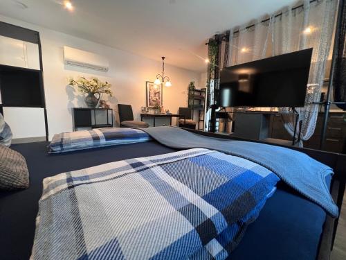 a bedroom with two beds and a flat screen tv at Dependance Villa Komposch adults only in Reifnitz