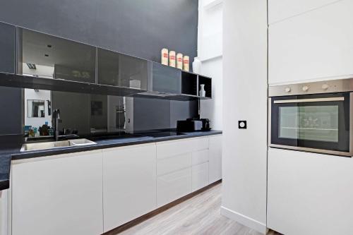 une cuisine blanche avec des armoires blanches et une fenêtre dans l'établissement Superb apartment with hammam -4BR-12P- Bastille, à Paris