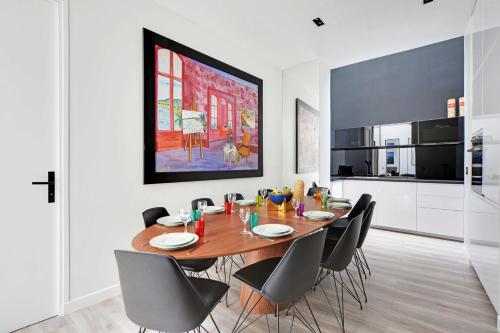 une salle à manger avec une table et des chaises en bois dans l'établissement Superb apartment with hammam -4BR-12P- Bastille, à Paris