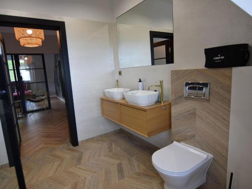 a bathroom with two sinks and a toilet at Apartment near Lake Radunskie in Stezyca in Stężyca