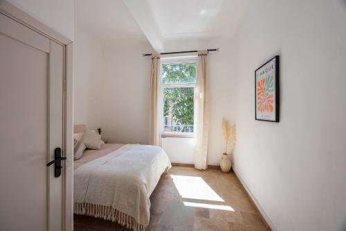 une chambre avec un lit et une fenêtre dans l'établissement La Suite Provençale, à Aix-en-Provence