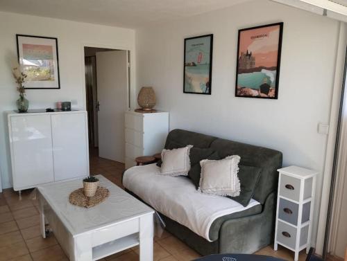 ein Wohnzimmer mit Sofa und Tisch in der Unterkunft Appartement avec terrasse in Quiberon