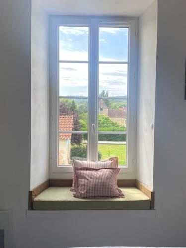 a window with a pillow on a window sill at Ancien Relais de Poste The Old Post Office in Saint-Martial-dʼAlbarède