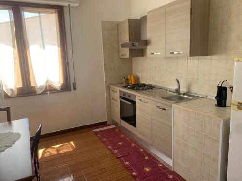 a kitchen with a sink and a stove top oven at Casa vacanze Lullo&Conny a 10 minuti dal mare in Quartucciu