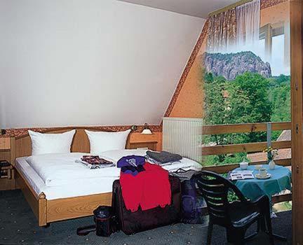 Amselgrundschlösschen في كورورت راتين: غرفة نوم بسرير وطاولة مع كرسي