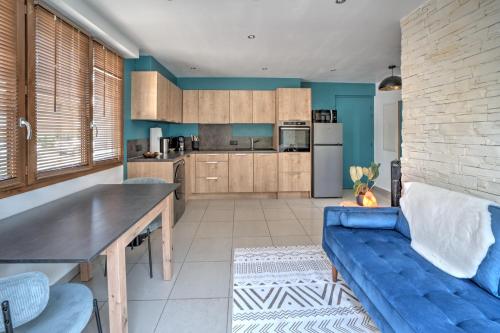 une cuisine avec des murs bleus et un canapé bleu dans l'établissement Le Bach - Charmant Appt à 10min de Annecy, à Annecy