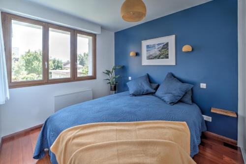 - une chambre bleue avec un lit king-size et des murs bleus dans l'établissement Le Bach - Charmant Appt à 10min de Annecy, à Annecy