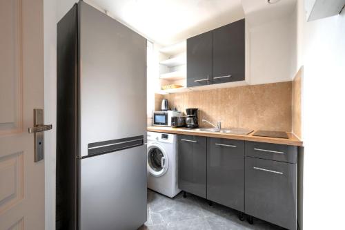 une cuisine avec un réfrigérateur et une machine à laver dans l'établissement Le Moulinet - Appt dans le 13e Arr de Paris, à Paris