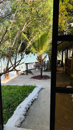 a view from a window of a beach with a palm tree at Z-Breeze Zanzibar in Kiwengwa