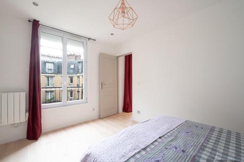 une chambre avec un lit et une grande fenêtre dans l'établissement Le Moulinet - Appt dans le 13e Arr de Paris, à Paris