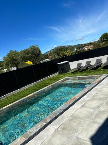 une piscine avec des chaises et une clôture dans l'établissement Villa dans le sud, à Saint-Mathieu-de-Tréviers