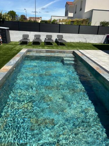 une piscine avec de l'eau bleue dans une cour arrière dans l'établissement Villa dans le sud, à Saint-Mathieu-de-Tréviers