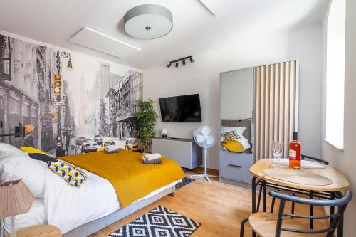 a bedroom with a yellow bed and a table at Apartament Na Deptaku 23 in Lublin