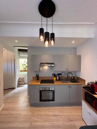 une cuisine avec un évier et une cuisinière dans l'établissement GAMBETTA - Lumineux Calme au coeur d'Antibes et de ses Plages, à Antibes