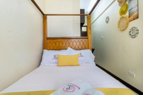 a small bedroom with a bed with a yellow pillow at ZaNaKri Homes ;A Great Panorama of Indian Ocean in Mombasa