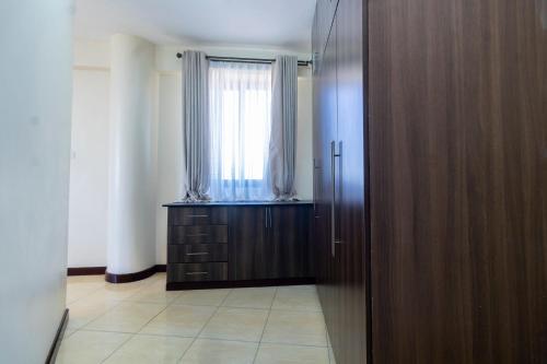 a room with a window and a wooden door at ZaNaKri Homes ;A Great Panorama of Indian Ocean in Mombasa
