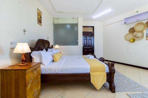 a bedroom with a bed and a table and a lamp at ZaNaKri Homes ;A Great Panorama of Indian Ocean in Mombasa