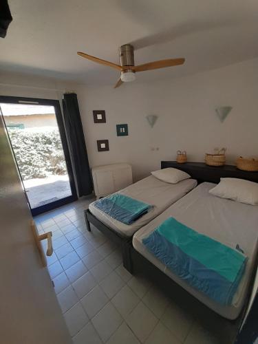 une chambre avec deux lits jumeaux et une fenêtre dans l'établissement Mas sympathique entre étang et mer !, au Barcarès