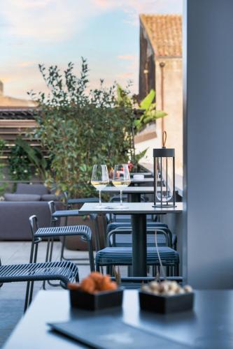 a table with chairs and wine glasses on a patio at Palazzo Sangiorgio in Catania