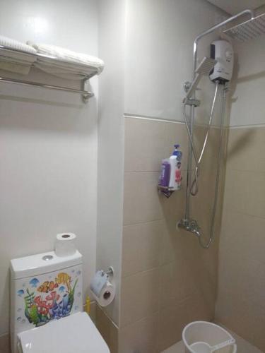 a bathroom with a shower and a toilet in it at SMDC Style Residences Condo Unit in Iloilo City