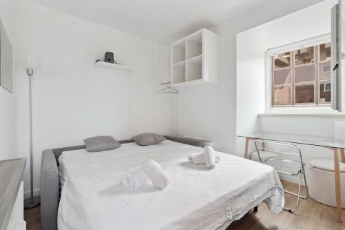 une chambre blanche avec un lit et un bureau dans l'établissement ID 412 - Cozy studio Near Eifel Tower, à Paris